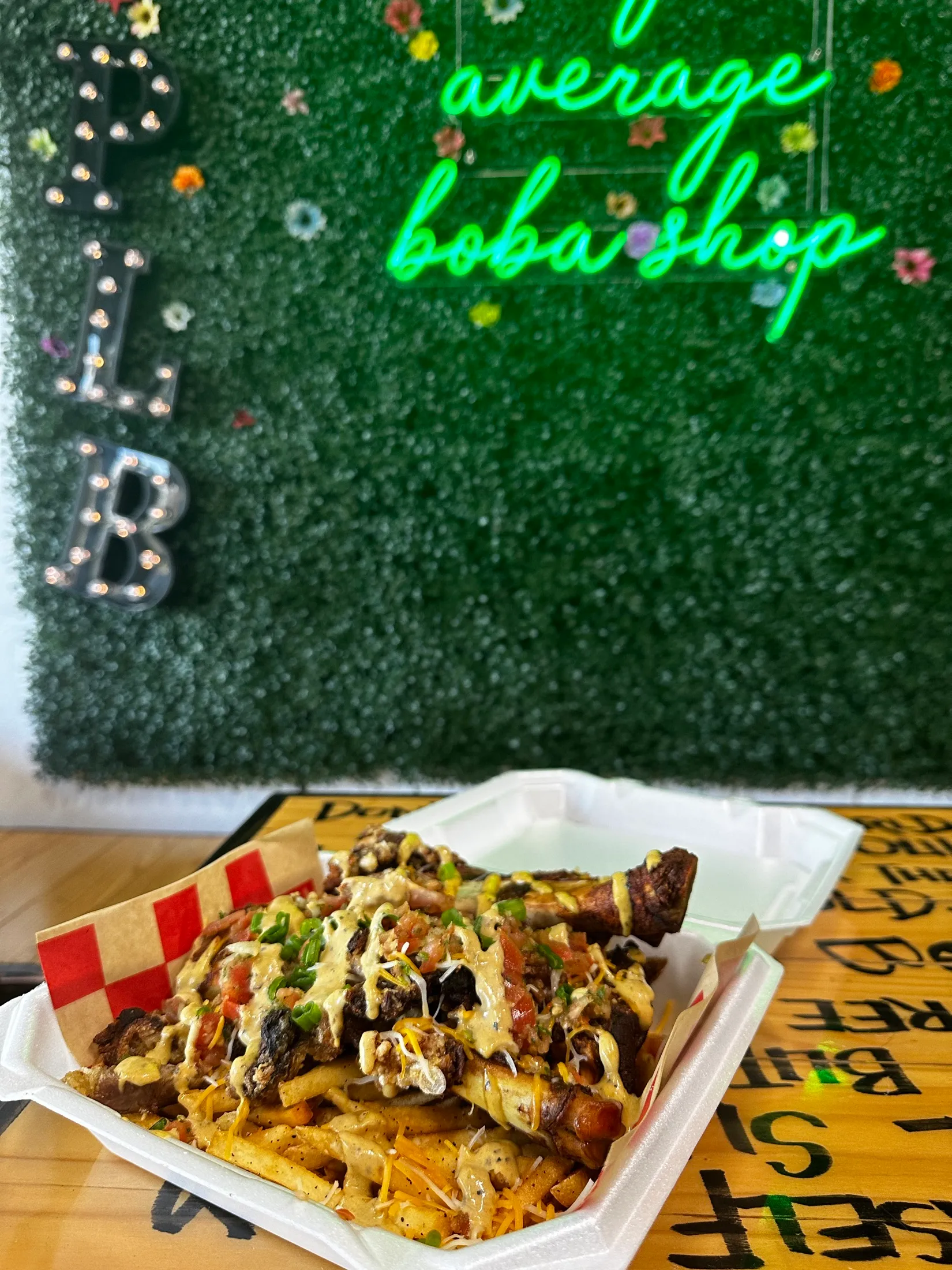 Loaded fries under the neon sign